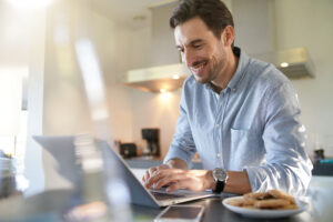 handsome man with computer modern kitchen